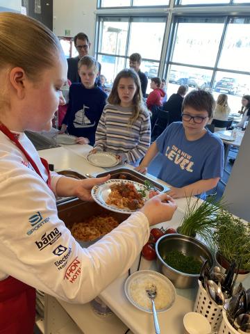 Landslagskokk Anette Myrhagen serverer mat til elevene ved Gaupen skole. – Elevene gledet seg til skolematen og vi har hatt kun positive erfaringer, forteller skolens lærere. 