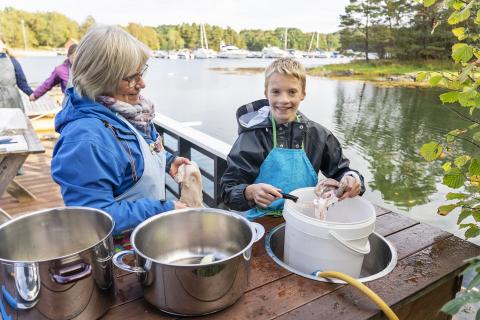 Bygdekvinne holder kurs med ung gutt. Foto: Ole Skaten, Tysnes Blad.