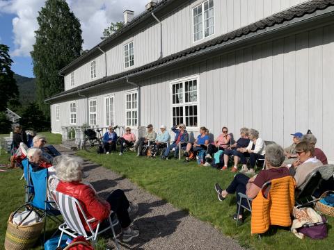 En fargerik gjeng samlet langs langveggen på Hovedgården