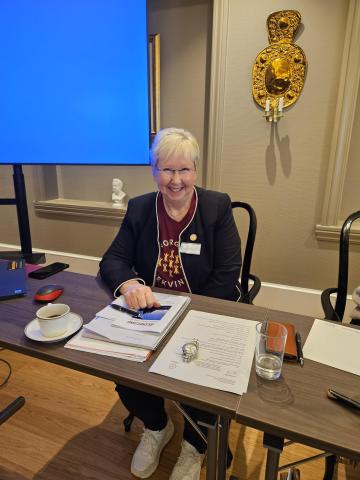 Dame ved møtebord, smiler