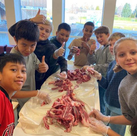 Glade skoleelever på Eidsvoll lærer å partere kjøtt. Foto: Eidsvoll Bygdekvinnelag. 