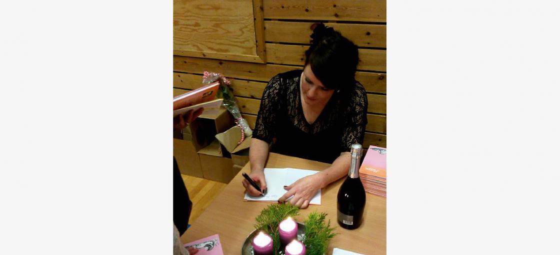 Solveig signerer boka til ivrige kjøpere