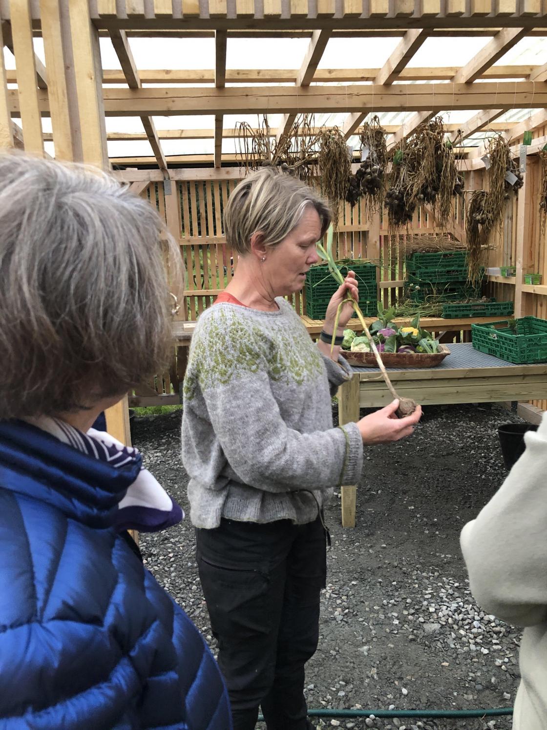 Hegelin forklarer om kvitløk og andre grønsaker dei har på garden.