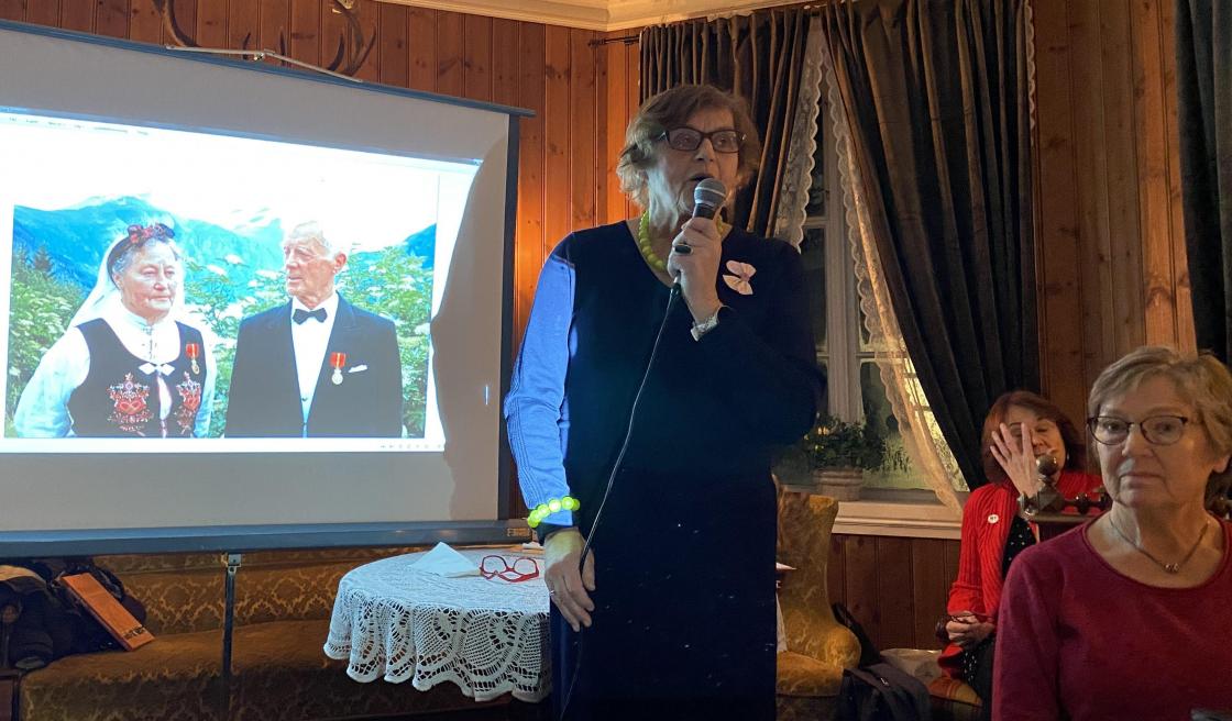 Solveig med bilde av Marta Linge som starta laget og var formann i 27 år.