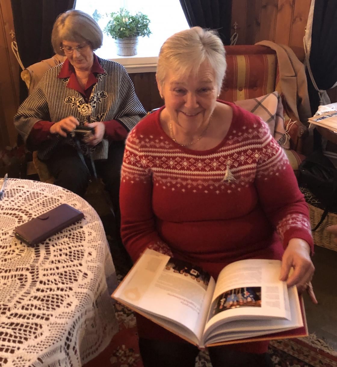 Aase studerer boka vår.