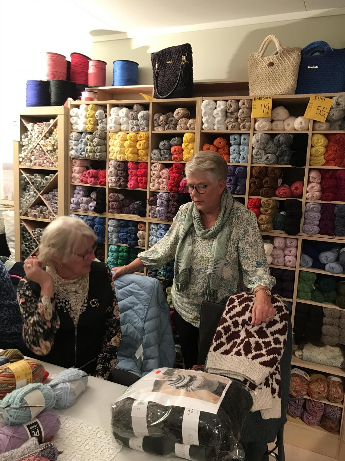 Lekre damer og flott garn i bakgrunnen