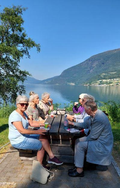 Turdeltakarar ved utebord i strålande vêr
