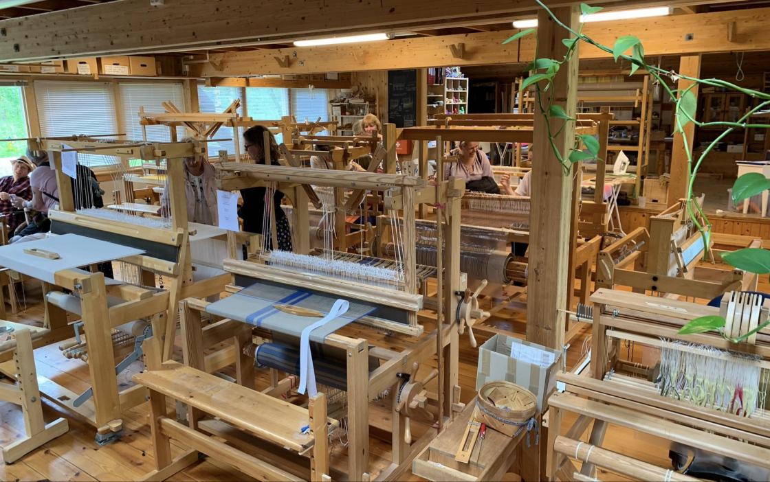 Veveriet med stor mangfoldighet av tekstiler som de selger i sin butikk i landsbyen