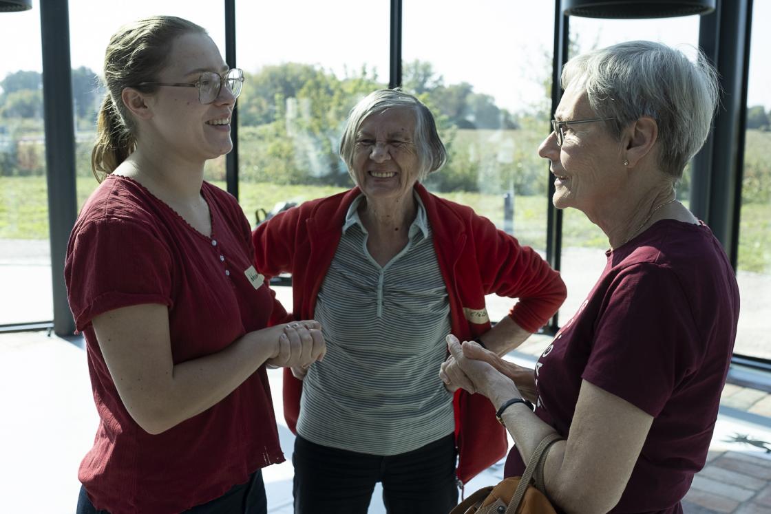 Tre smiande damer i samtale