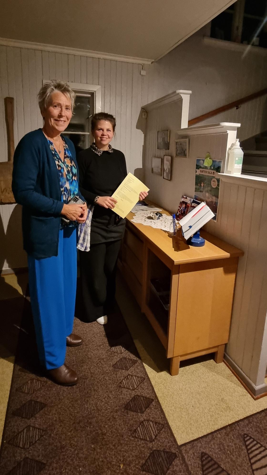 Forfatter og en kjøper som står ved et bord med barnebøker