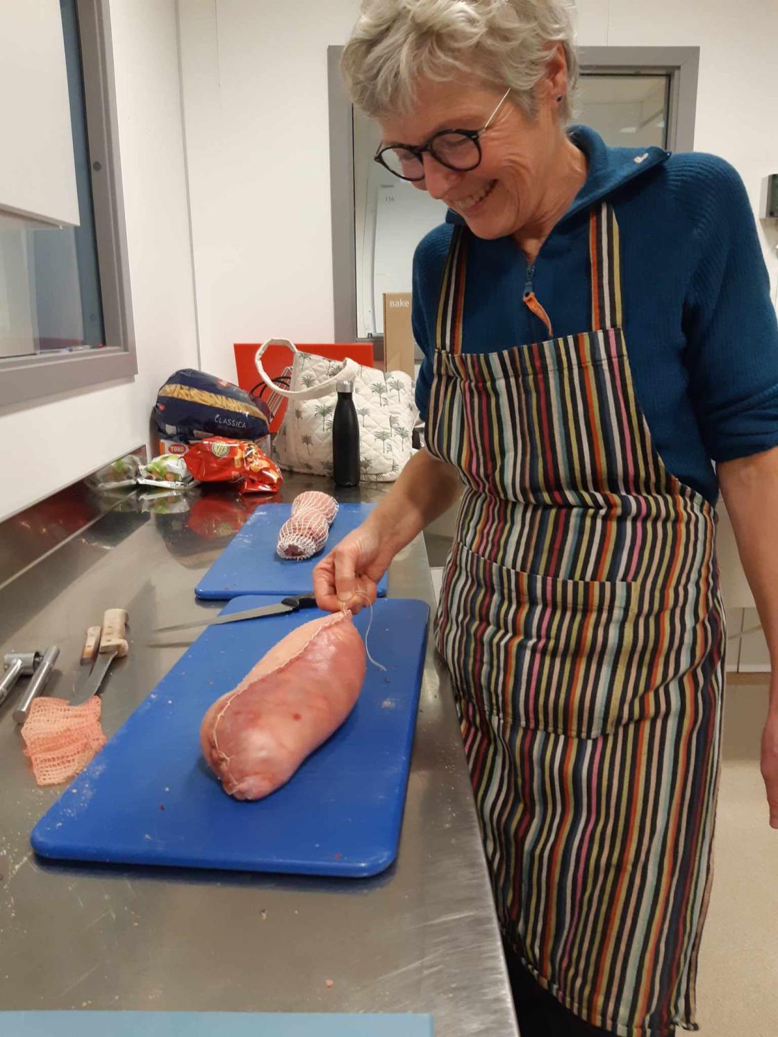 Kvinne med kjøttrull som er ferdig rullet