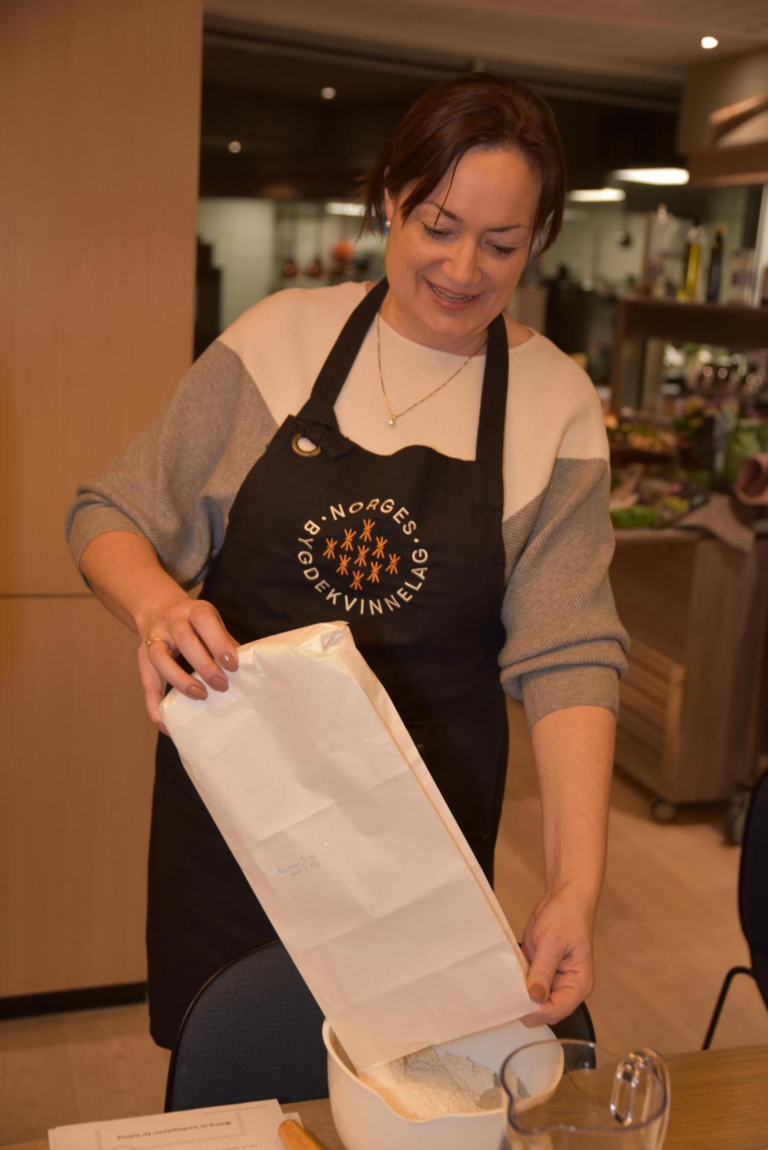 Ragnhild Male Hartviksen blander i mel i surdeigen. Foto: Helle Cecilie Berger.