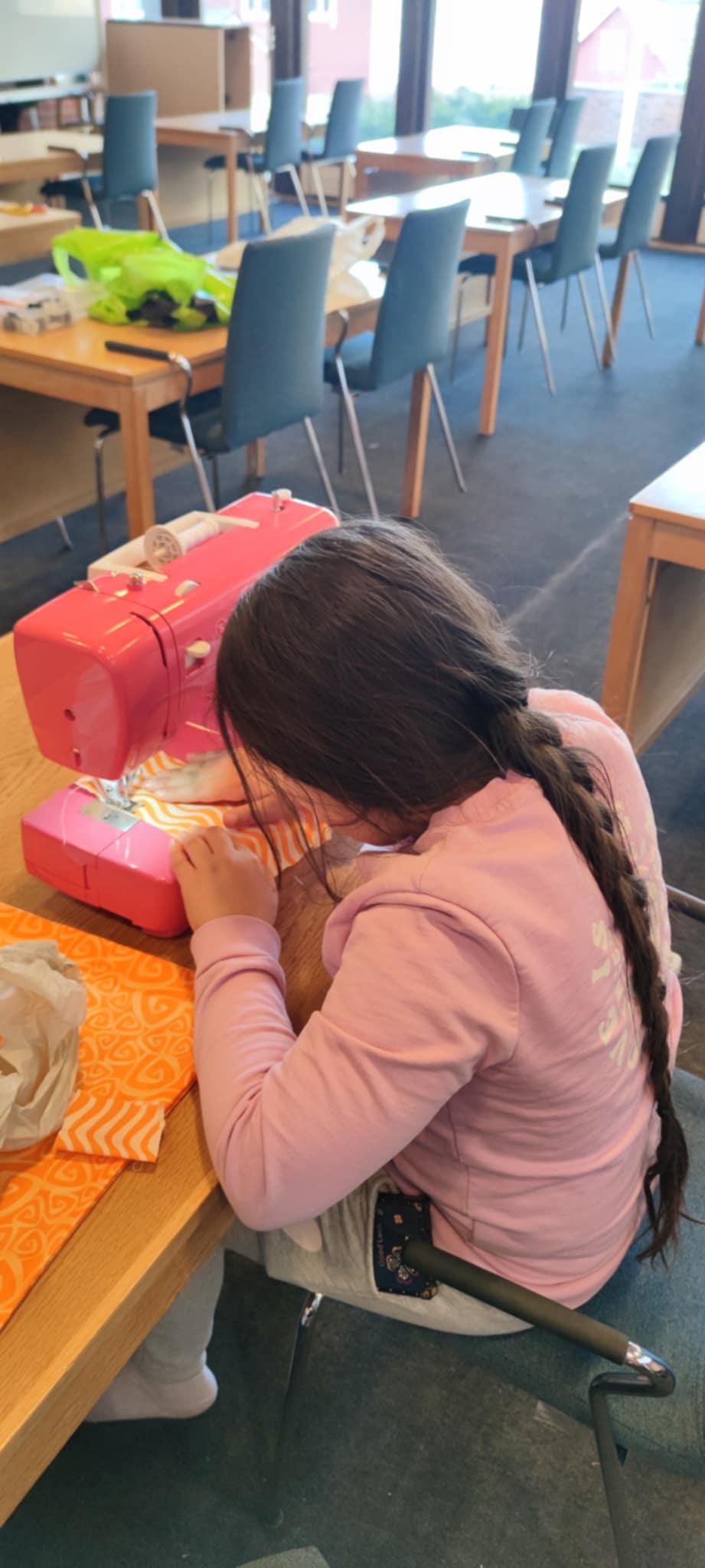 Jente som syr på symaskin