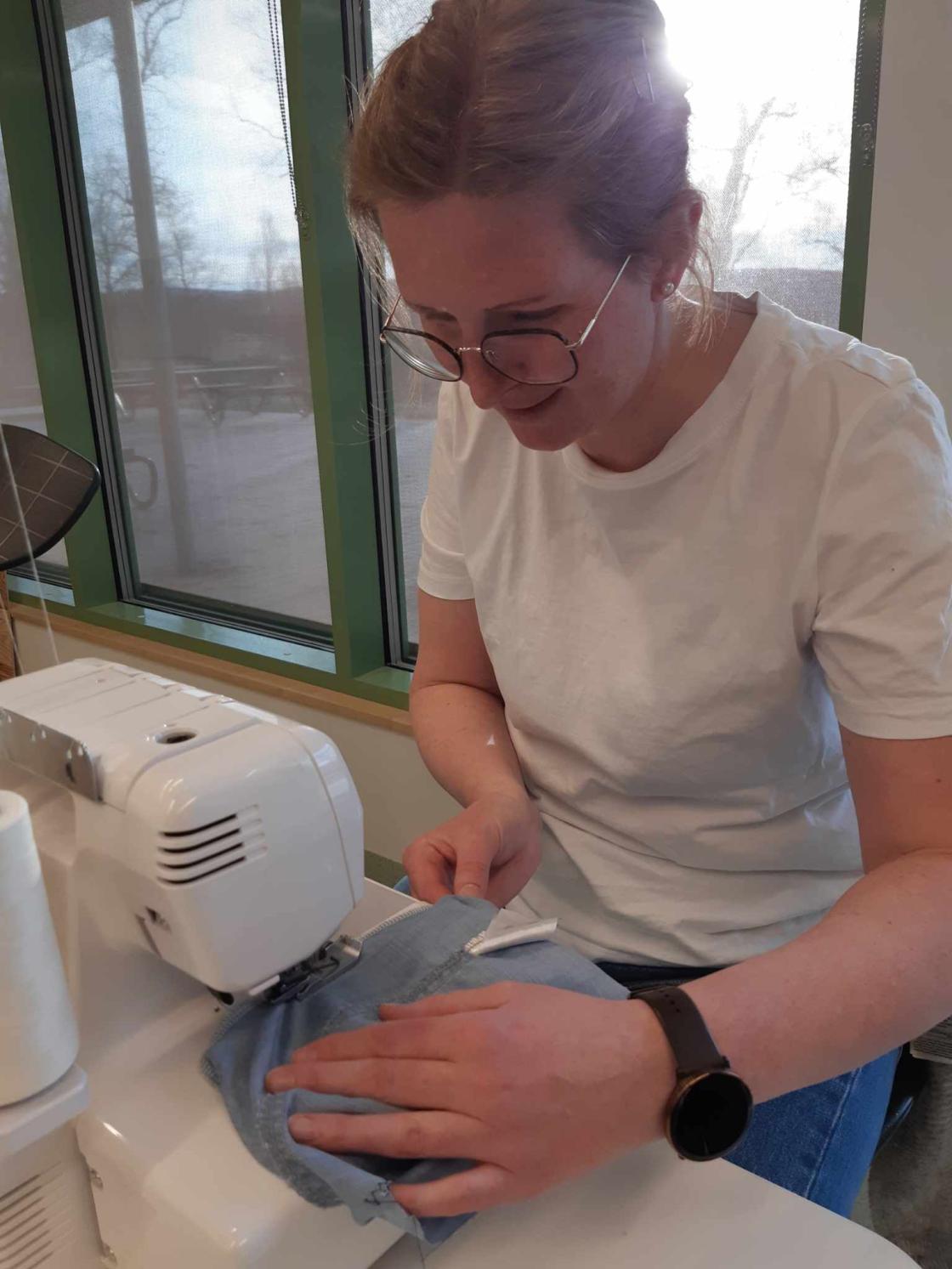 Kvinne syr på maskin