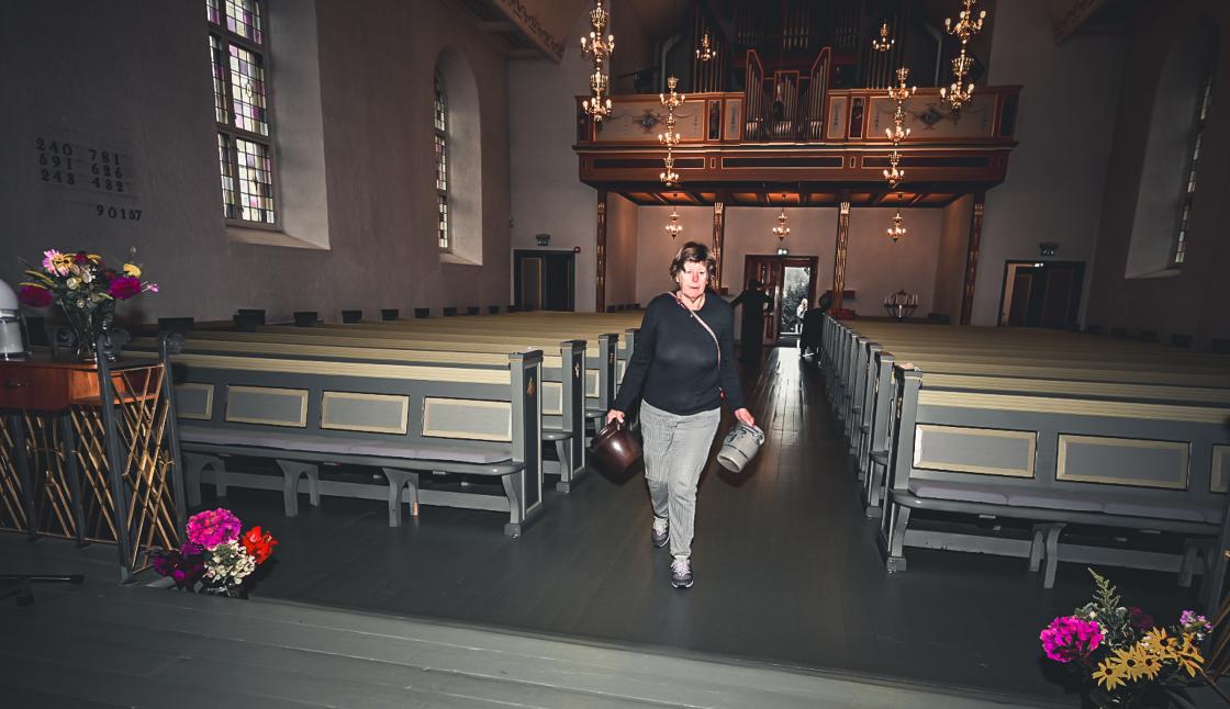 Wenche bærer med seg krukker for å fylle med blomster