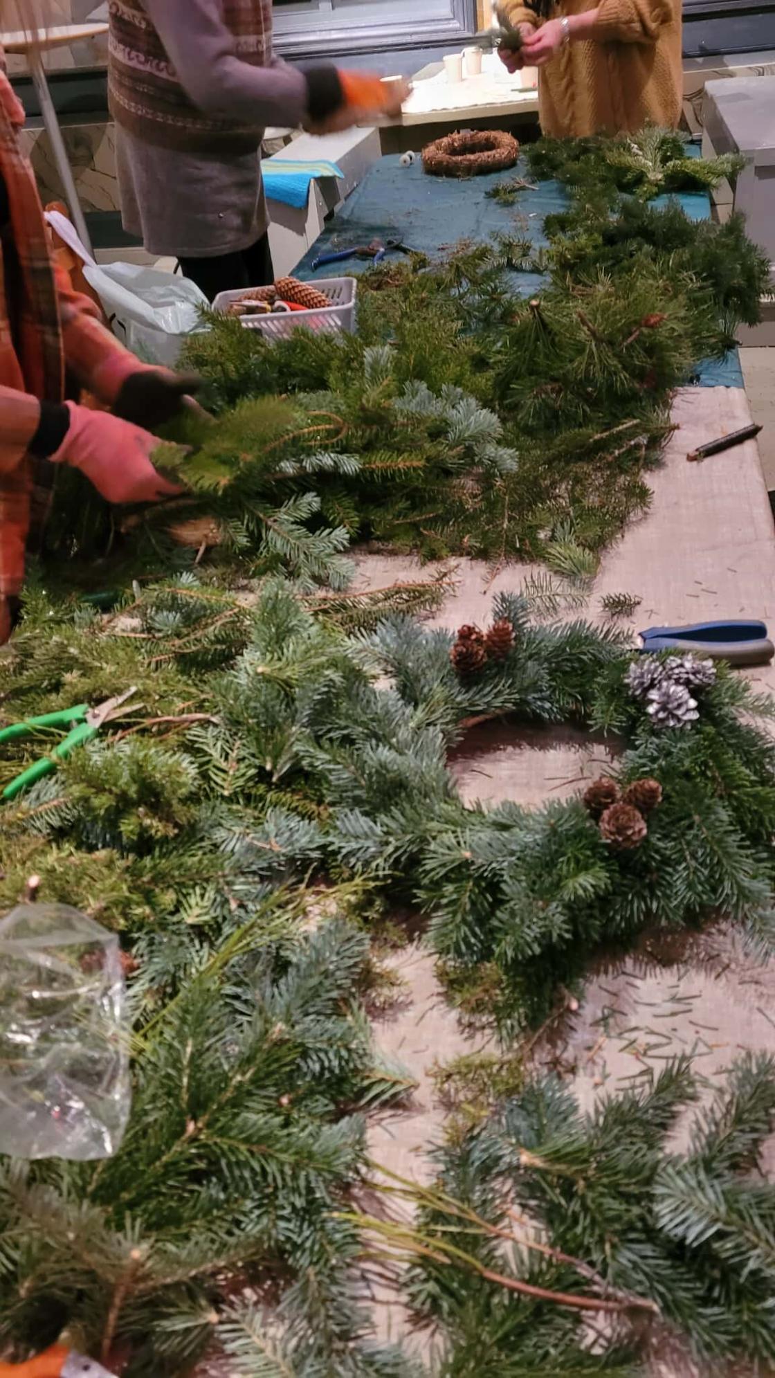 Bord med julekranser og hender som jobber flittig