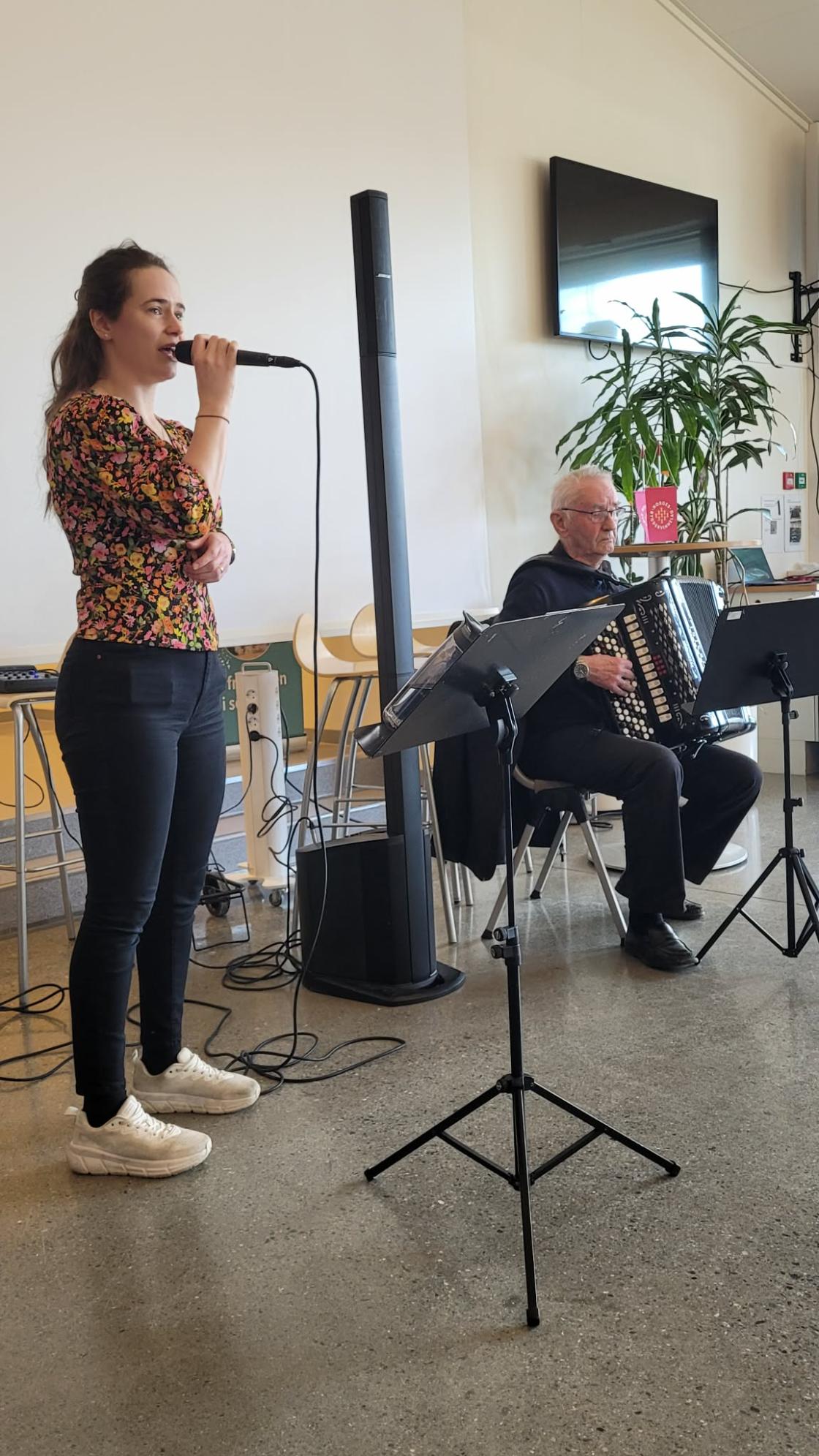 Kvinne synger og mann spiller trekkspill