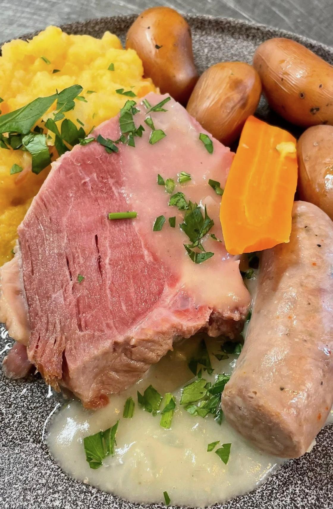 Salta  svinekjøtt med poteter, kålrotstappe, pølse og løksaus