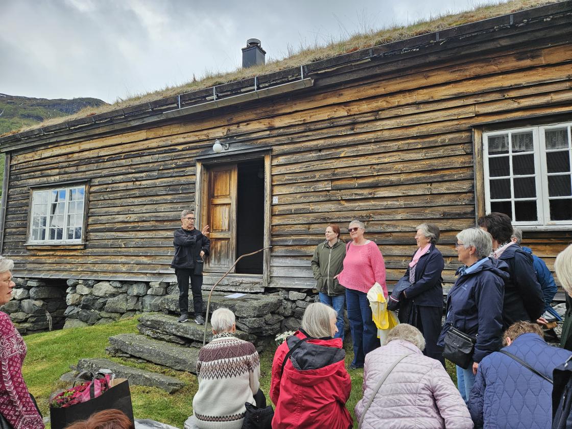 Folk framfor gamalt hus
