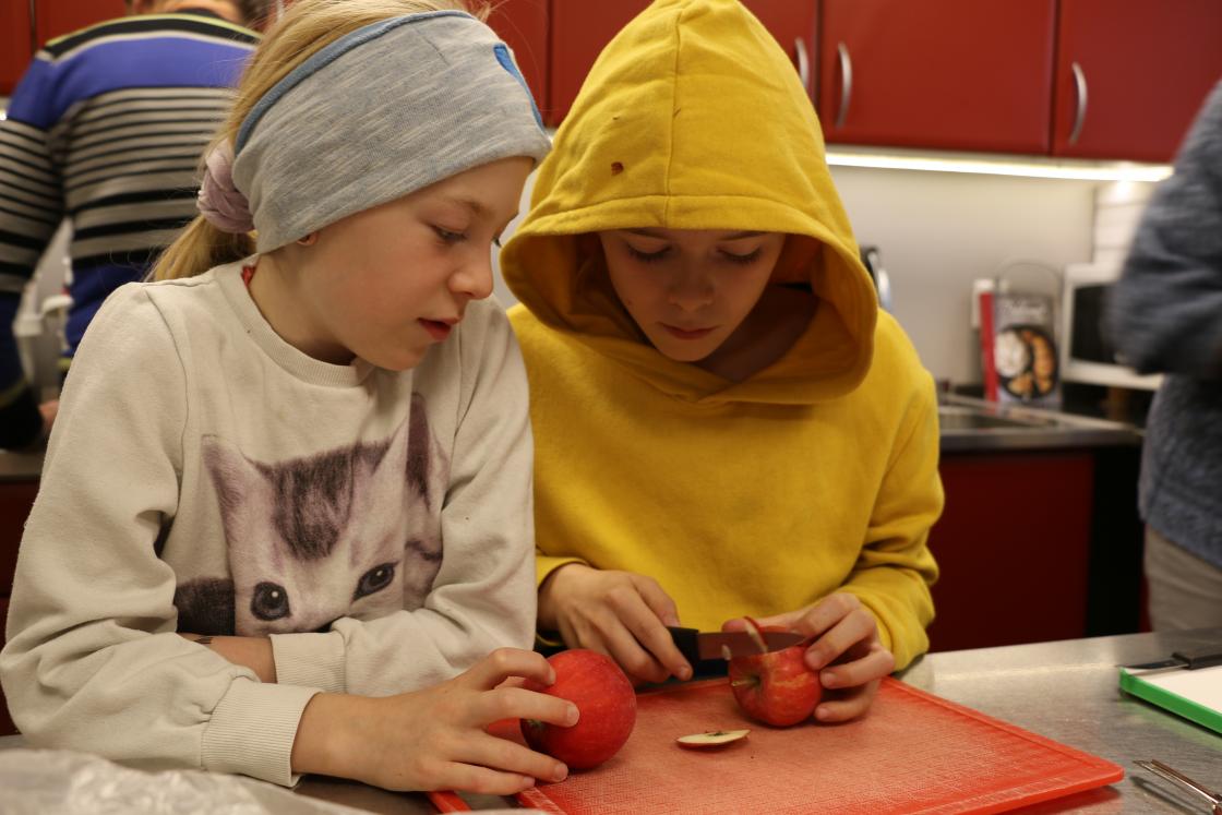 Tvillingene Thea Marie og Sverre Alexander Risstad (10) er dypt konsentrert mens de kutter eplene med den skarpe kniven. Foto: Toril Langmo Skjetne.