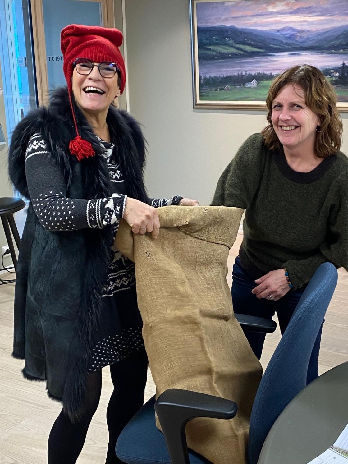 Julenisse Jorun Henriksen deler ut julegaver til styremedlemmene i Norges Bygdekvinnelag. Her får nestleder Unni J. Skadsem sin julegave. Foto: Helle Berger.