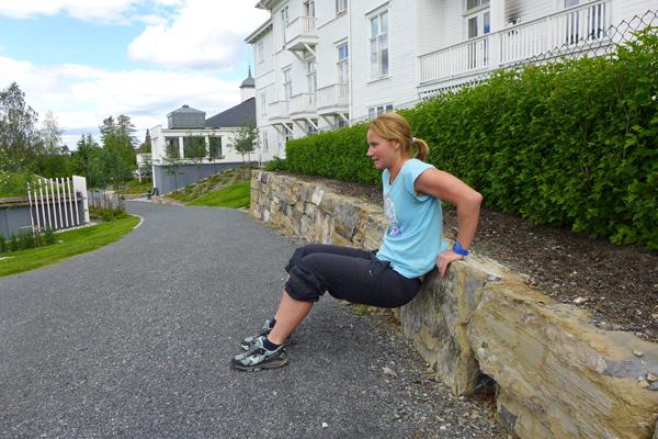 Dips: Bøy i albuen og senk kroppen ned mot bakken. NB! Albuen skal peike bakover. Press opp att. Om det blir for tungt trekk du beina nærmare kroppen. 10-15 gonger x 2. Foto: May-Britt Sægrov.