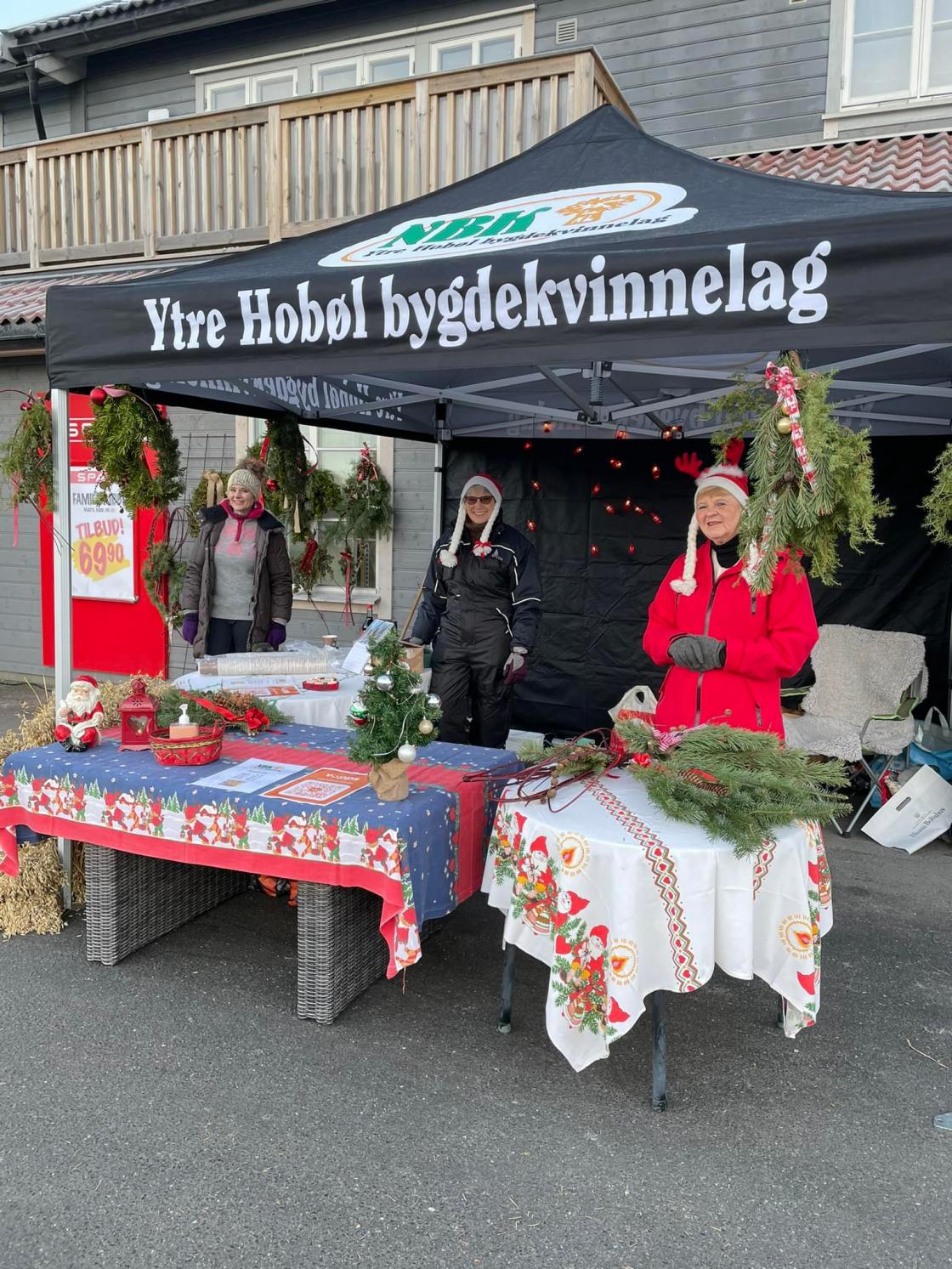 Ytre Hobøl Bygdekvinnelag inviterte til julemarked der de solgte juletrær, julenek og dørkreasjoner som de hadde laget selv. Foto: Ytre Hobøl Bygdekvinnelag.
