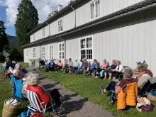 En fargerik gjeng samlet langs langveggen på Hovedgården