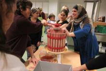 Samling rundt eplepressa: Ghazala Ibrahim og Awaz Hamed fra Syria, og Alyaa Makhzumi fra Irak var ivrig ved eplepressa. Det ble mye latter da det etter hvert ble en tung jobb å presse ut safta. Foto: Ragnhild Bakke.