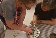 Torhild og Agnes limer på fliser
